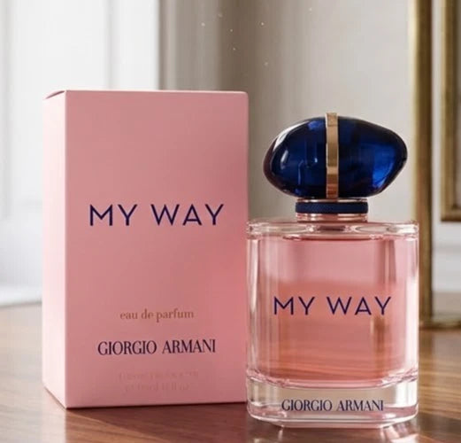 Giorgio Armani My Way Eau de Parfum bottle with its pink packaging box, displayed on a wooden surface with a soft-focus indoor background.