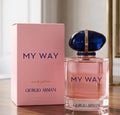 Giorgio Armani My Way Eau de Parfum bottle with its pink packaging box, displayed on a wooden surface with a soft-focus indoor background.