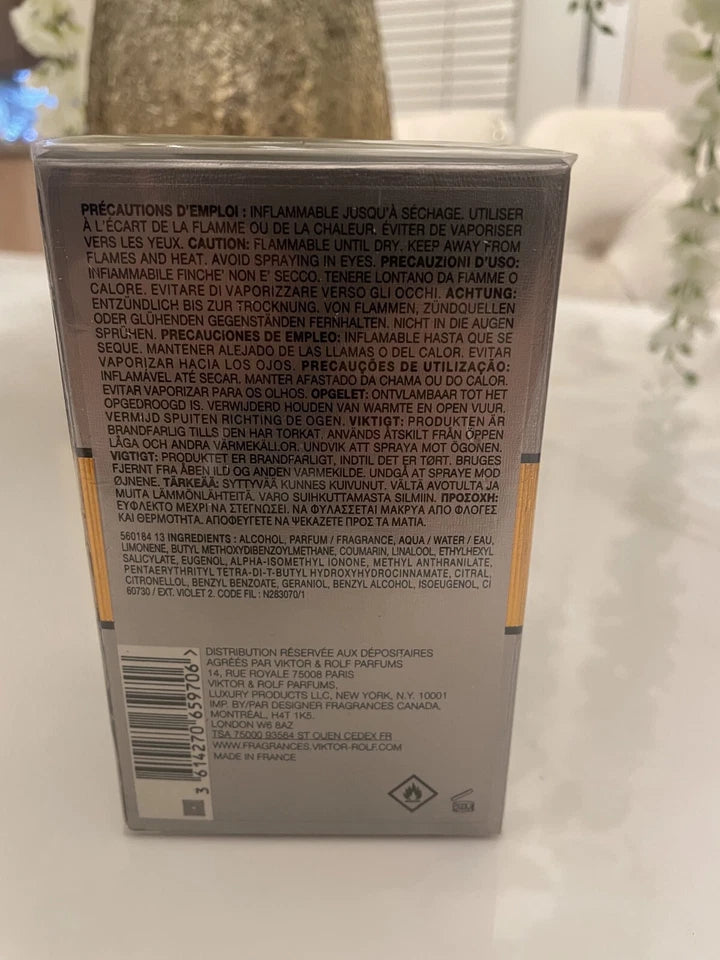 The back of a rectangular product box with dense black warning and usage text in French and English, photographed on a light surface with a blurred indoor background.