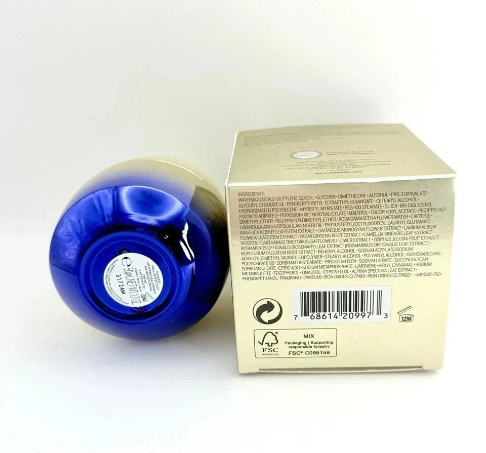 A blue cosmetic bottle lying on its side next to its beige cardboard packaging box, showing the back of the box with text, barcode, and recycling symbols on a white background.