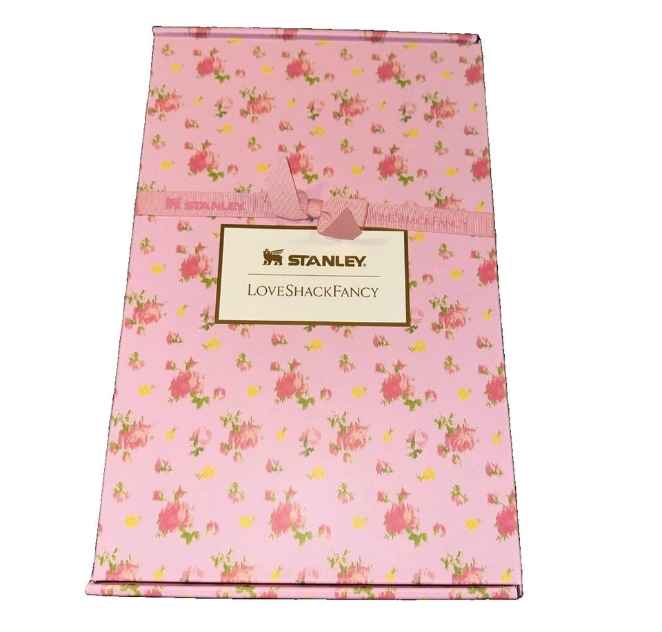 A pink floral gift box with a matching pink ribbon and a central label that reads 'STANLEY LOVESHACKFANCY'.