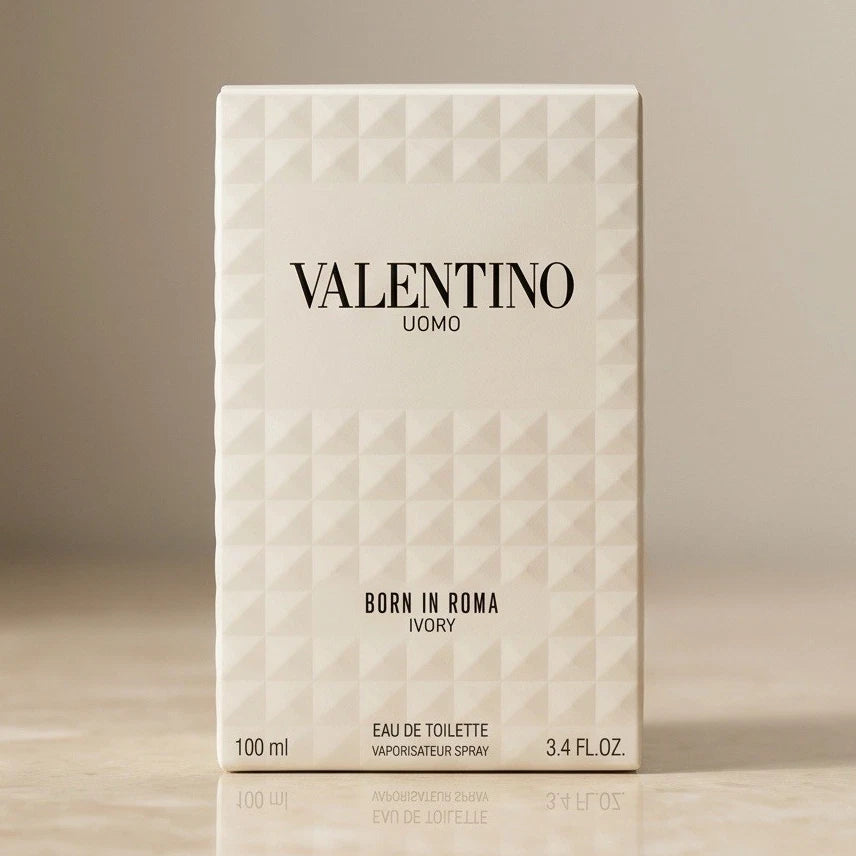 A rectangular box of Valentino Uomo Born in Roma Ivory Eau de Toilette, featuring a textured geometric diamond pattern in off-white on a neutral beige background.
